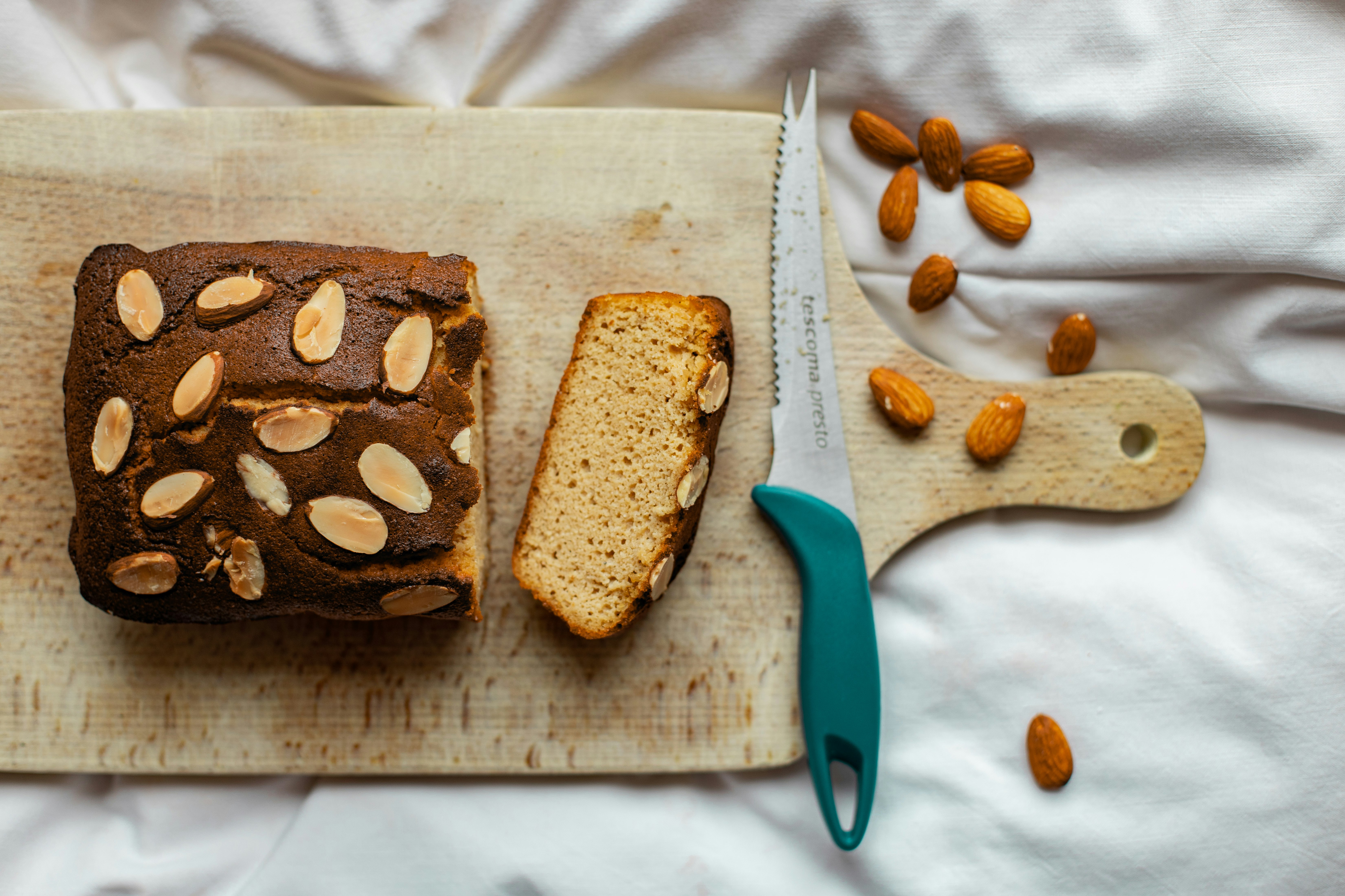 blue handled scissors beside brown bread